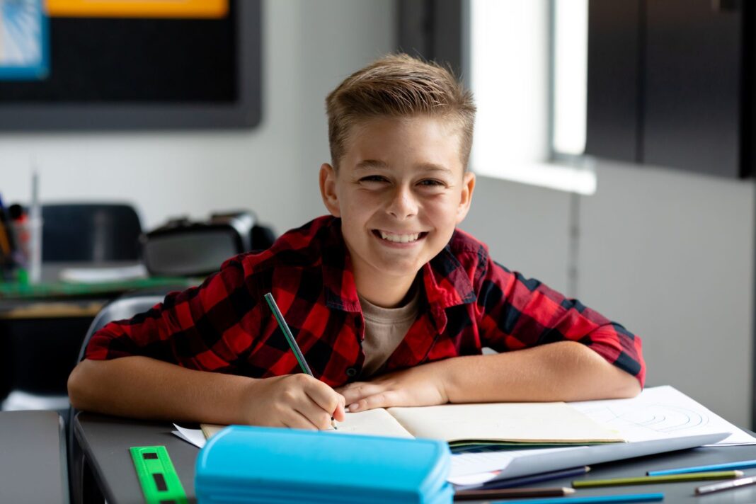 Jeune garçon qui rédige sa lettre de motivation pour entrer dans un collège privée